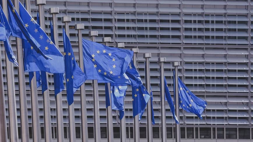 European Union flag in front of a government building, representing EU AI Act regulatory negotiations